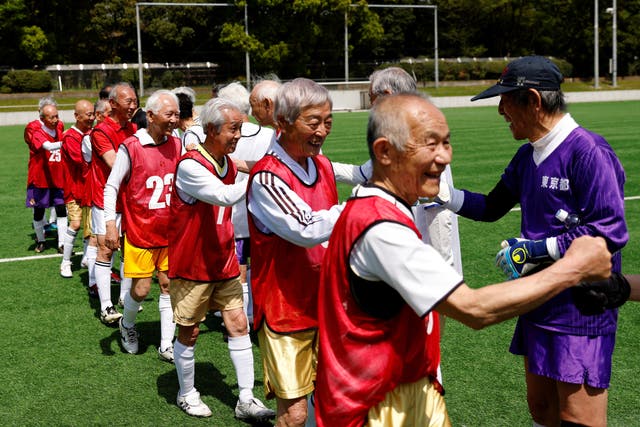 <p>Red Star’s midfielder Mutsuhiko Nomura, 83, and White Bear’s goalkeeper Shingo Shiozawa, 93, greet their opponents at the SFL (Soccer For Life) 80 League opening match in Tokyo, Japan</p>