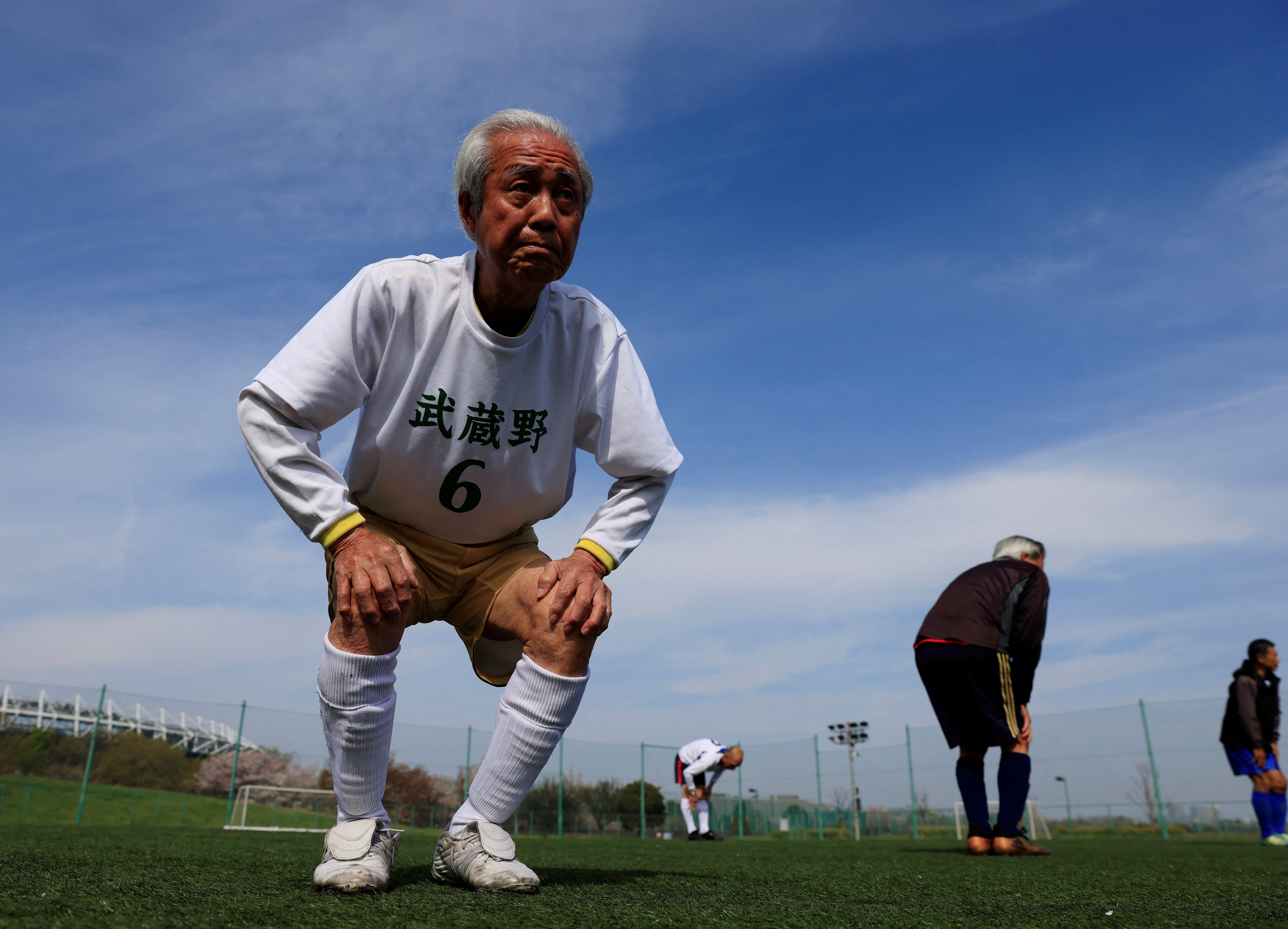 Nomura, 83, stretches during a practice with his TAFF (Tama Area Friday Football) teammates, a football team where the players’ average age is 65