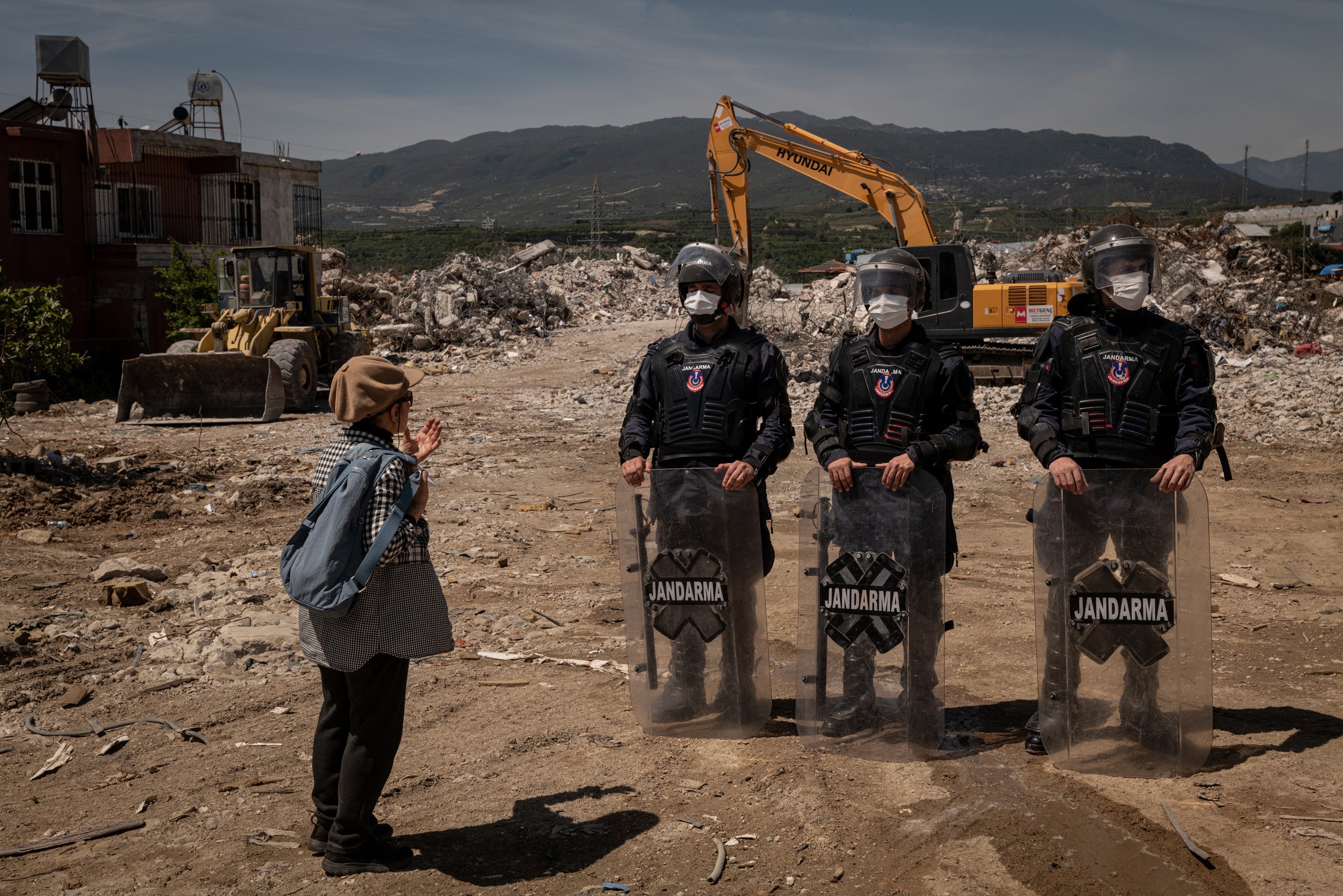 A protester speaks to Turkish military police guarding the site of a rubble dump