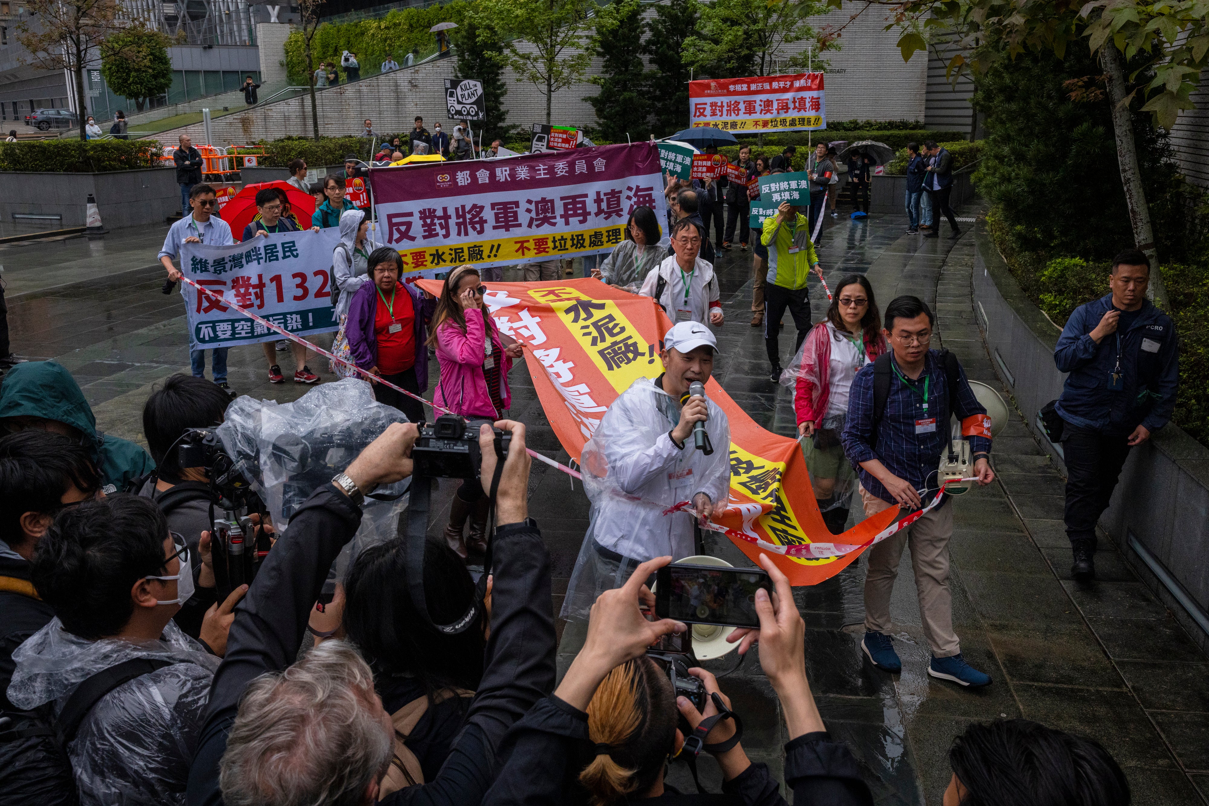 File. Protesters walk within a cordon line wearing number tags during a rally in Hong Kong, 26 March 2023