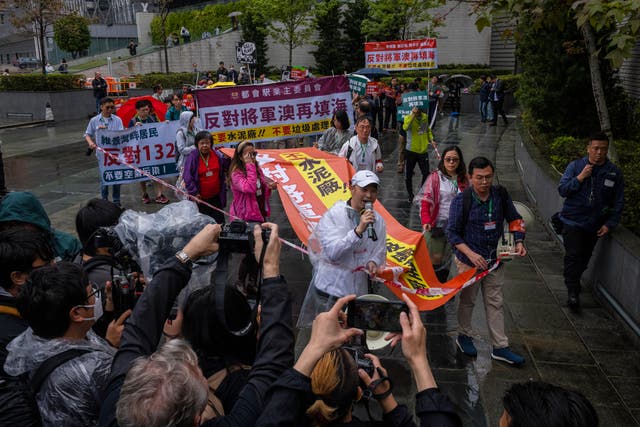 <p>File. Protesters walk within a cordon line wearing number tags during a rally in Hong Kong, 26 March 2023</p>