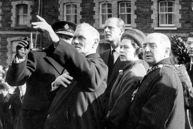 Queen Elizabeth II and the Duke of Edinburgh follow the pointing finger of local resident Councillor Jim Williams, who lost seven members of his family in the Aberfan disaster. On the right is the Mayor of Merthyr Tydfil, Alderman Stanley Davies (PA)