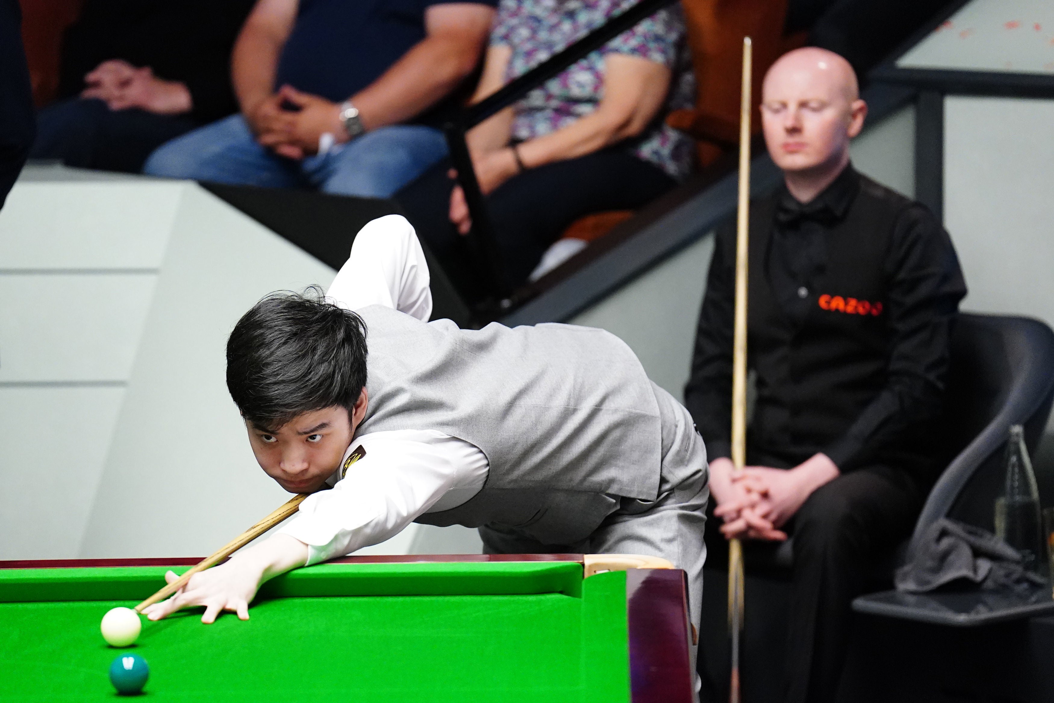 Anthony McGill watches on as Si Jiahui takes to the table