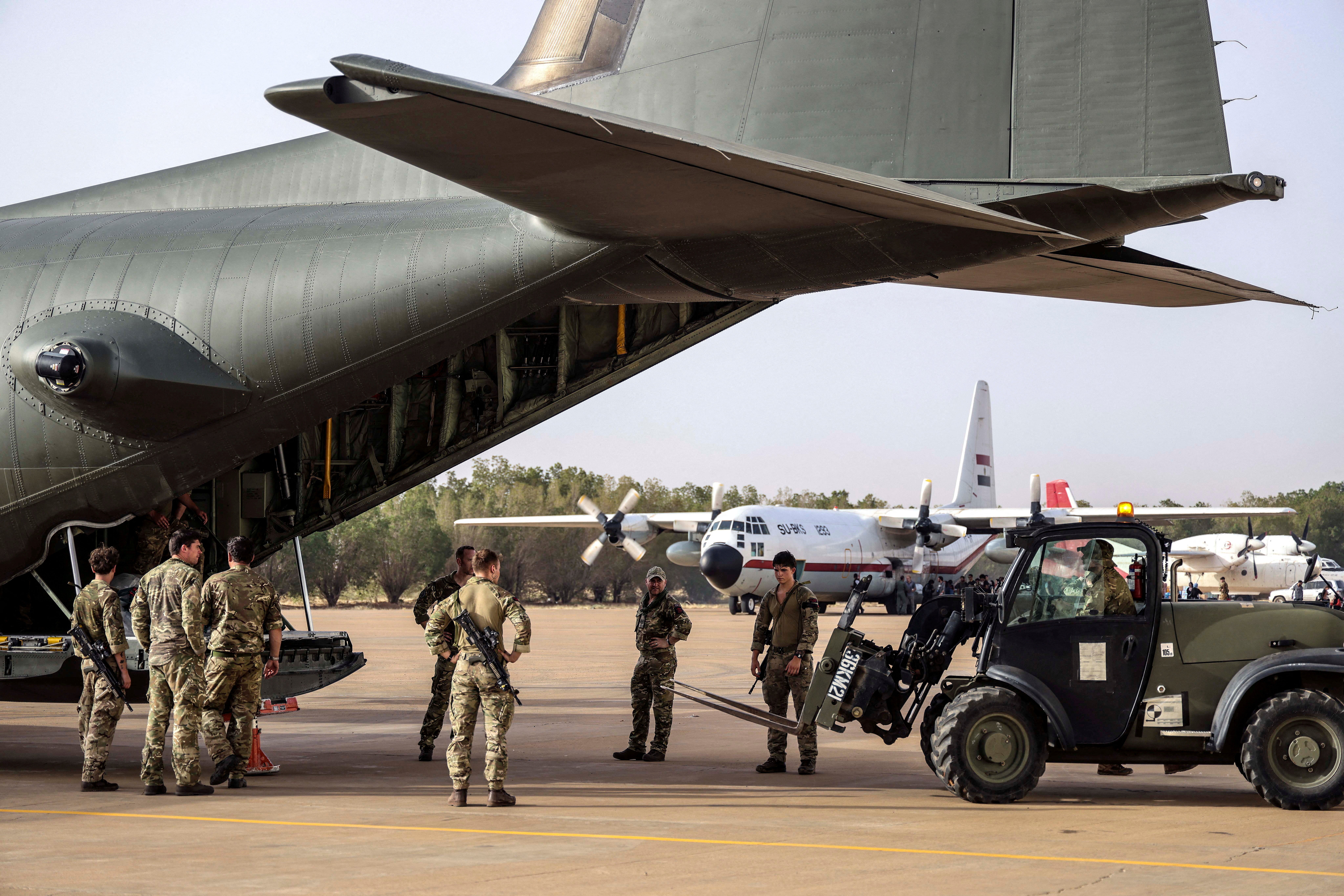 Military personnel unload stores during the evacuation of British citizens, at Wadi Seidna airport