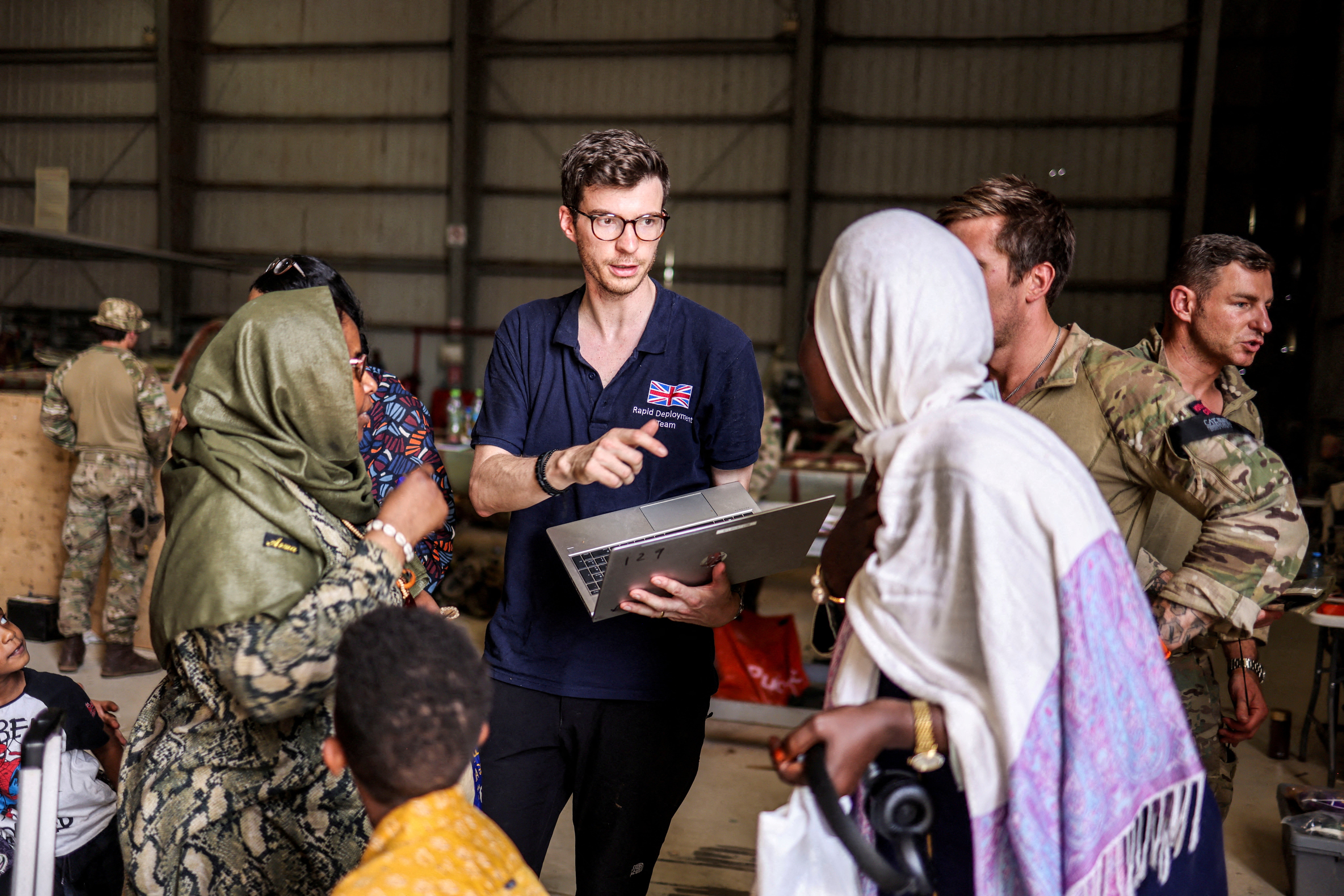 A Foreign and Commonwealth Rapid Response team member helps evacuees before they fly to Cyprus