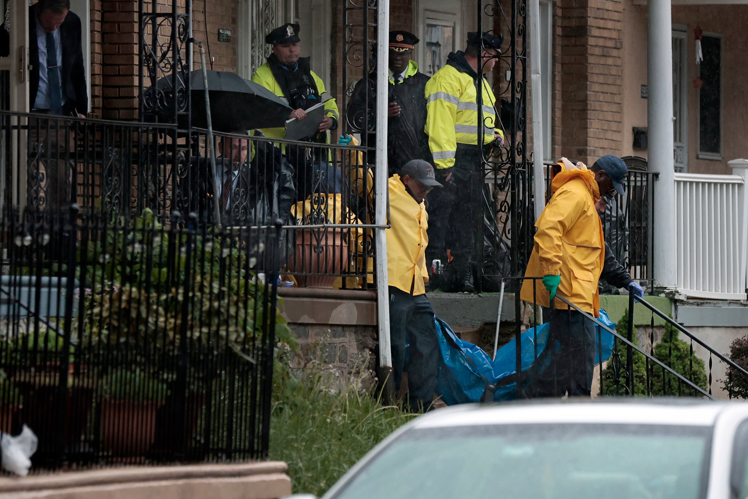 A body is removed as police investigate the scene of a quadruple shooting on the 5900 block of Palmetto Street in Philadelphia’s Crescentville section on Friday