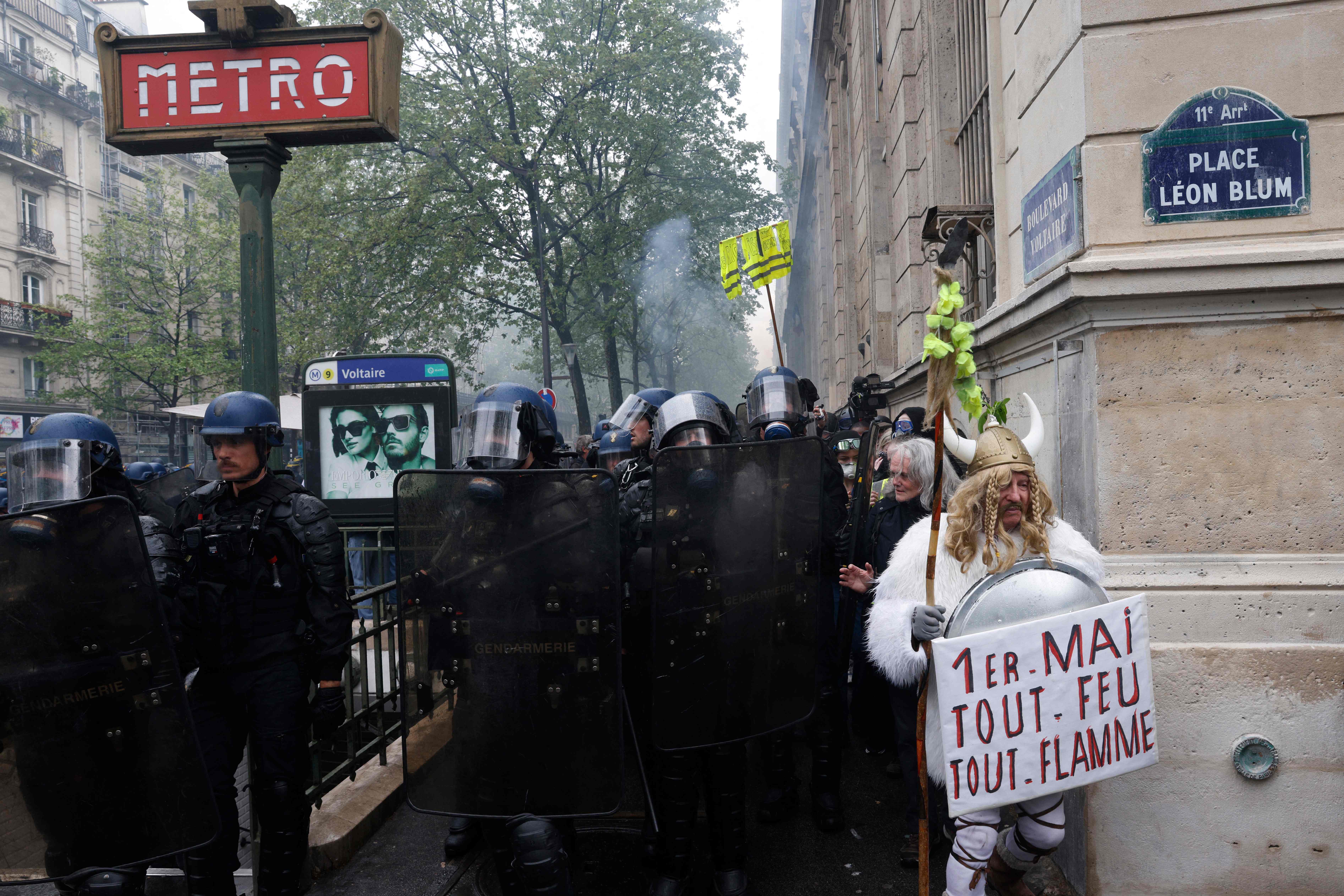 A protester dressed in Gallic attire stands in front of a police cordon on Monday