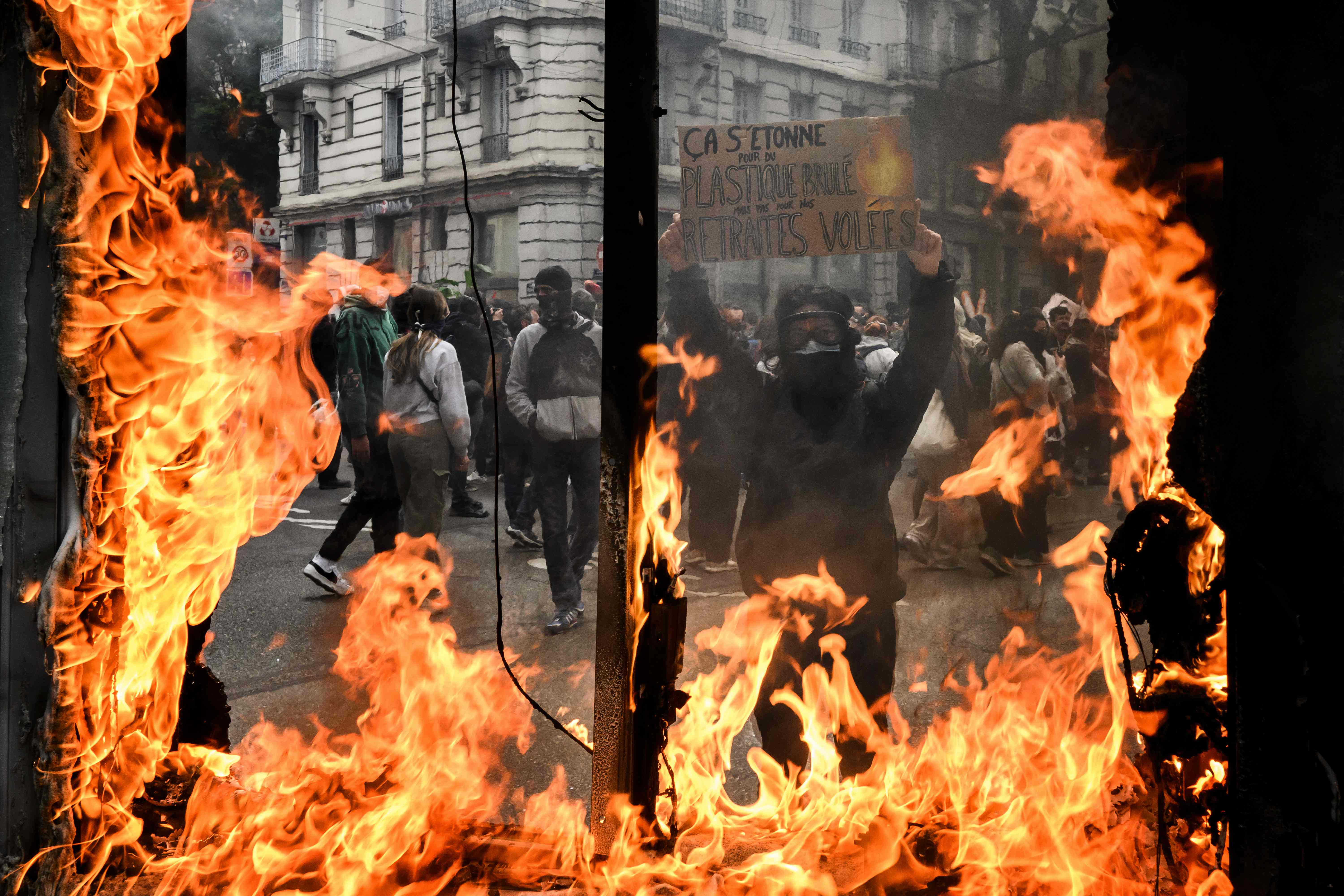 <p>‘Choked by burnt plastic but not by our stolen pensions,’ says a protest sign in Lyon</p>