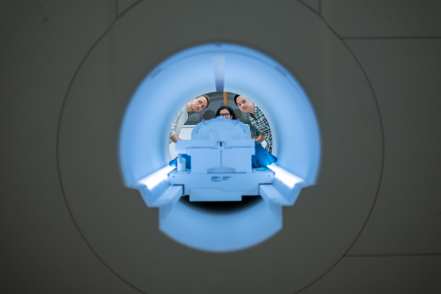 <p>Researchers Alex Huth (left), Jerry Tang (right) and Shailee Jain (centre) prepare to collect brain activity data in the Biomedical Imaging Center at The University of Texas at Austin</p>
