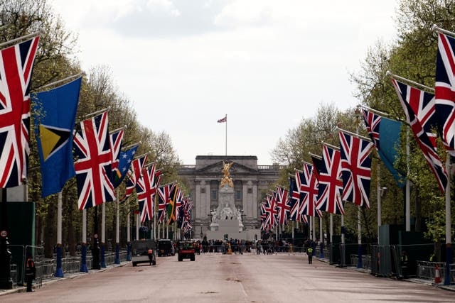 Union flags hang outside Buckingham Palace on the Mall (Jordan Pettitt/PA)