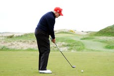 Trump poses for photographers to get perfect shot as he plays golf in Scotland