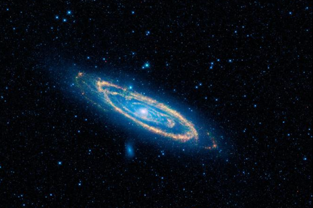<p>A false-color image of the mid-infrared emission from the Great Galaxy in Andromeda, as seen by Nasa’s WISE space telescope</p>