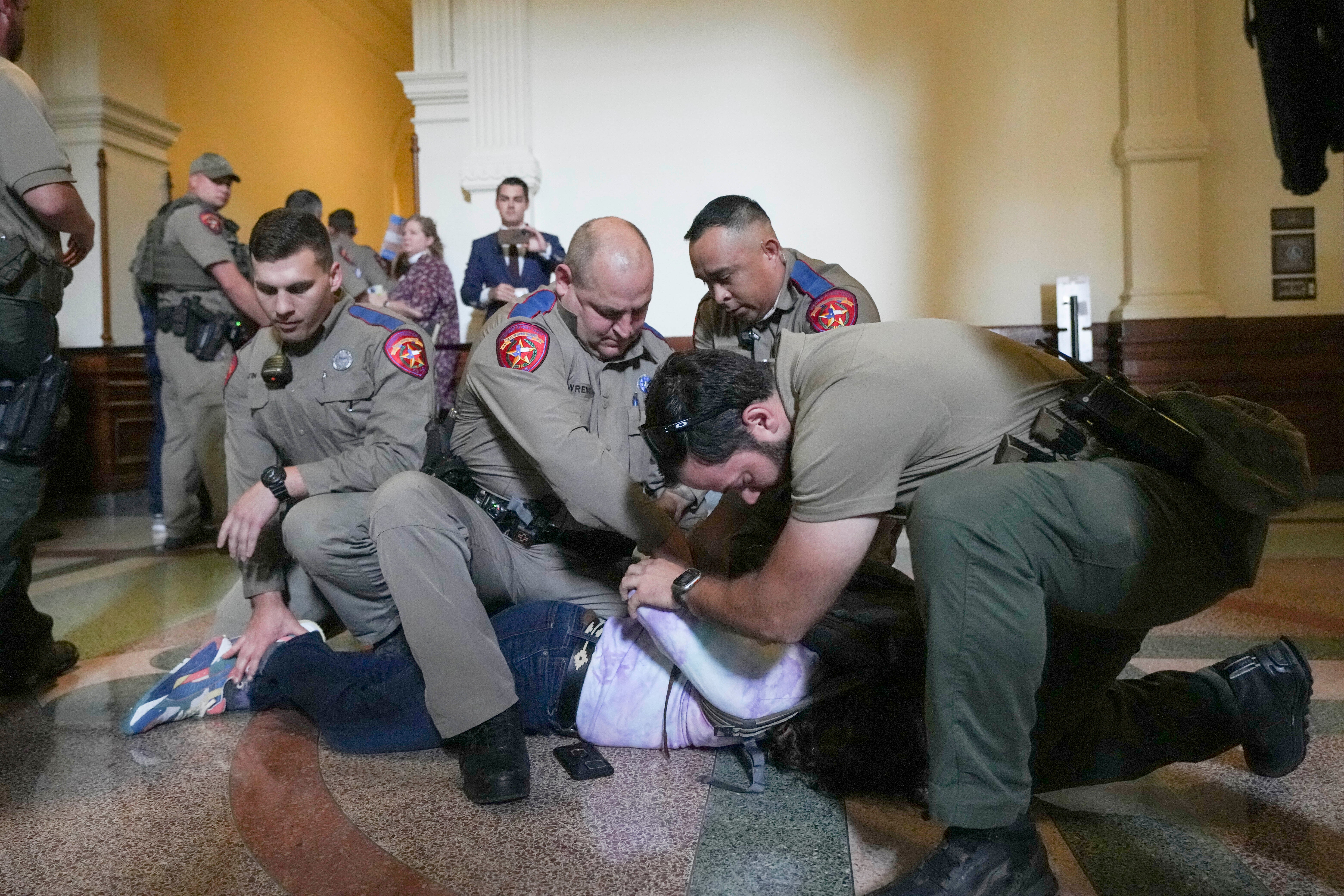 An LGBT+ rights activist is detained by Department of Public Safety troopers as activists protest SB14 outside the House of Representatives gallery at the Texas State Capitol in Austin