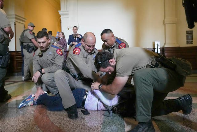 <p>An LGBT+ rights activist is detained by Department of Public Safety troopers as activists protest SB14 outside the House of Representatives gallery at the Texas State Capitol in Austin</p>
