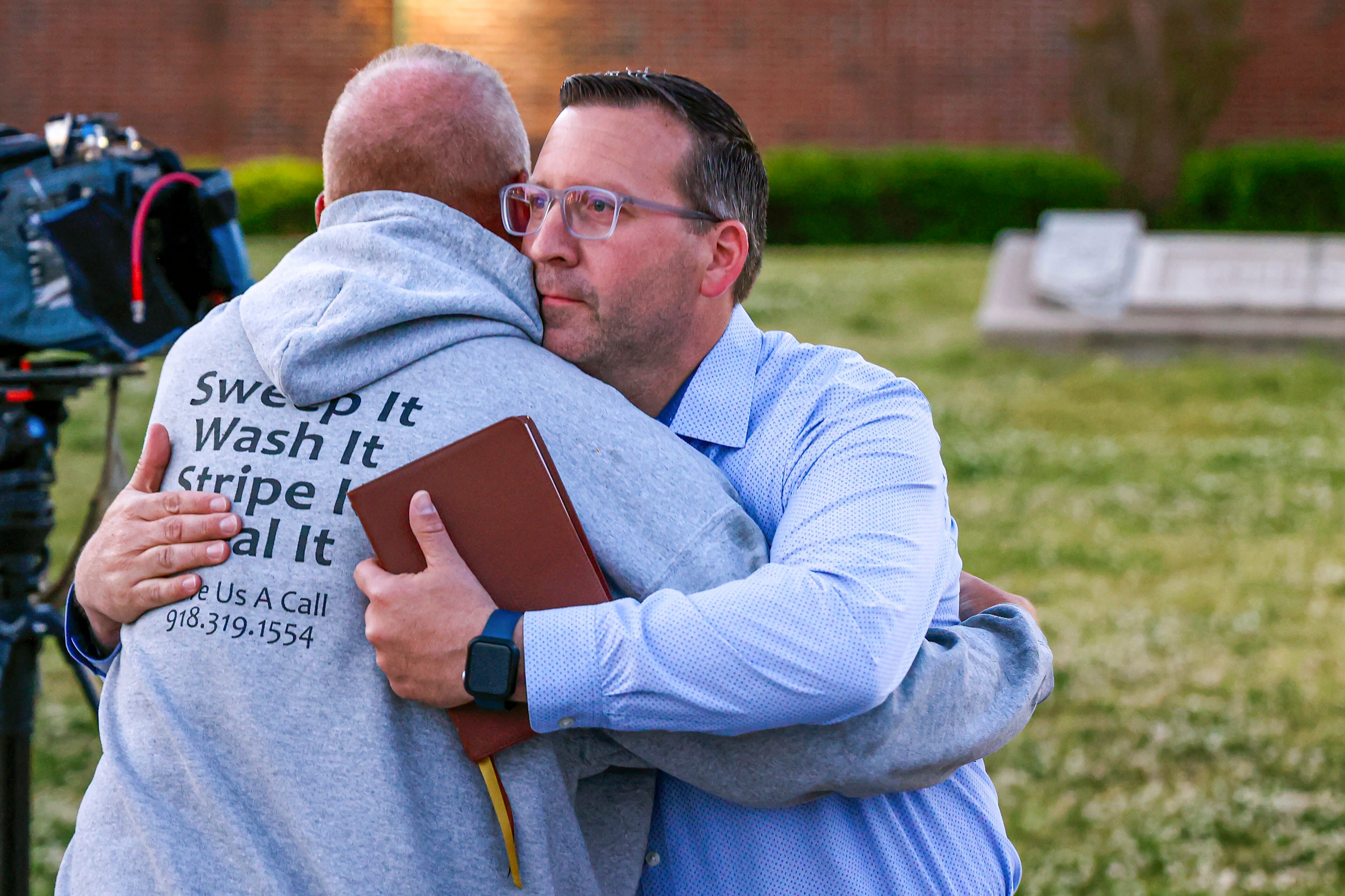 Pastor Ryan Wells hugs Nathan Brewer, the father of Brittany Brewer who was found dead, after a vigil in Henryetta