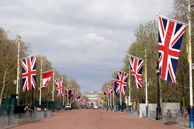 <p>Union flags hang from the street furniture outside Buckingham Palace on the Mall (Jordan Pettitt/PA)</p>