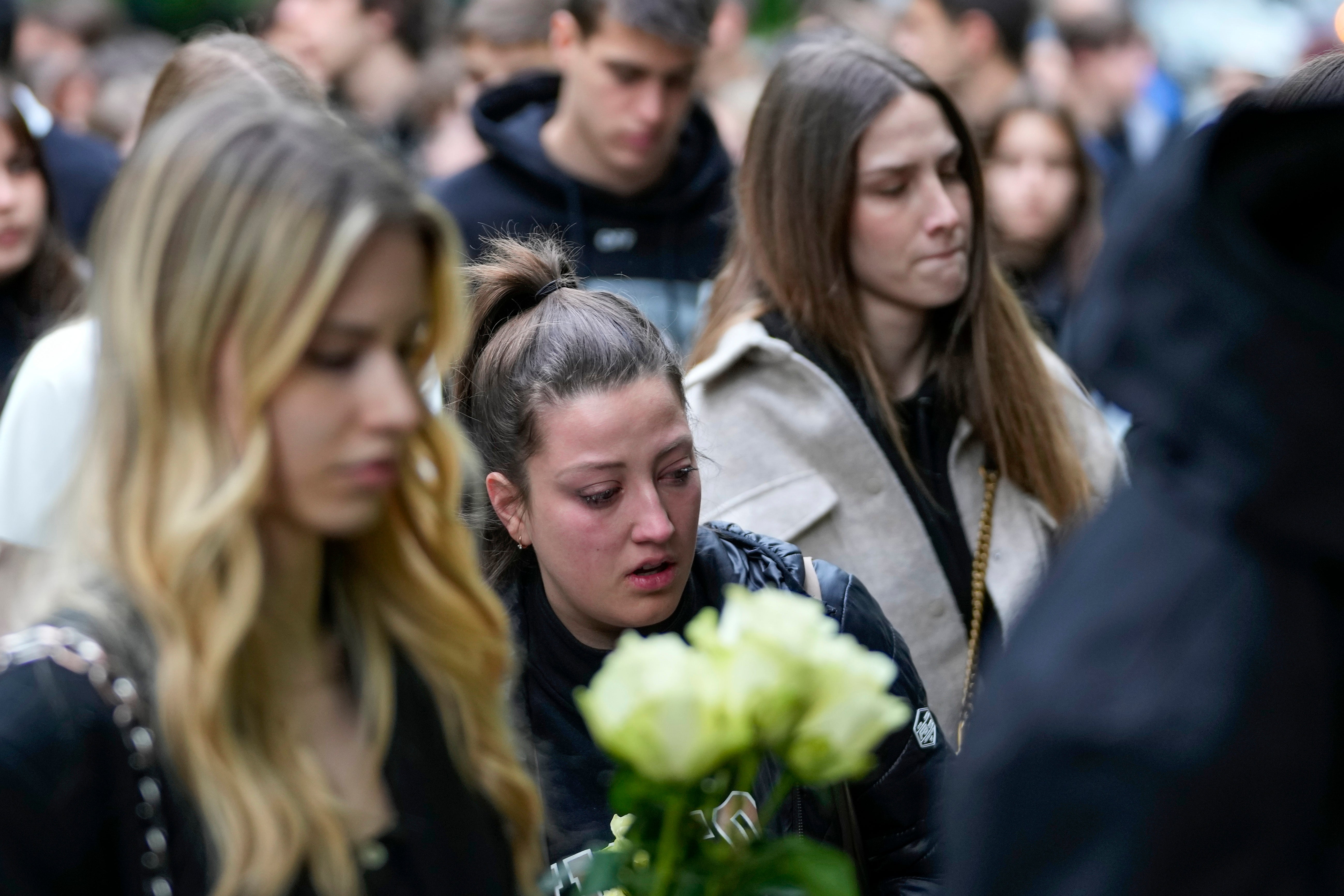 People bring flowers for the victims in front of the Vladimir Ribnikar school in Belgrade