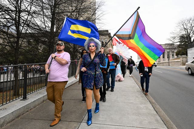 <p>Protesters carrying the Pride flag and a flag</p>