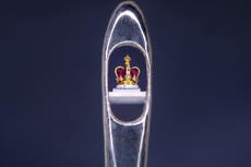 Sculptor creates tiny crown in the eye of a needle as coronation tribute