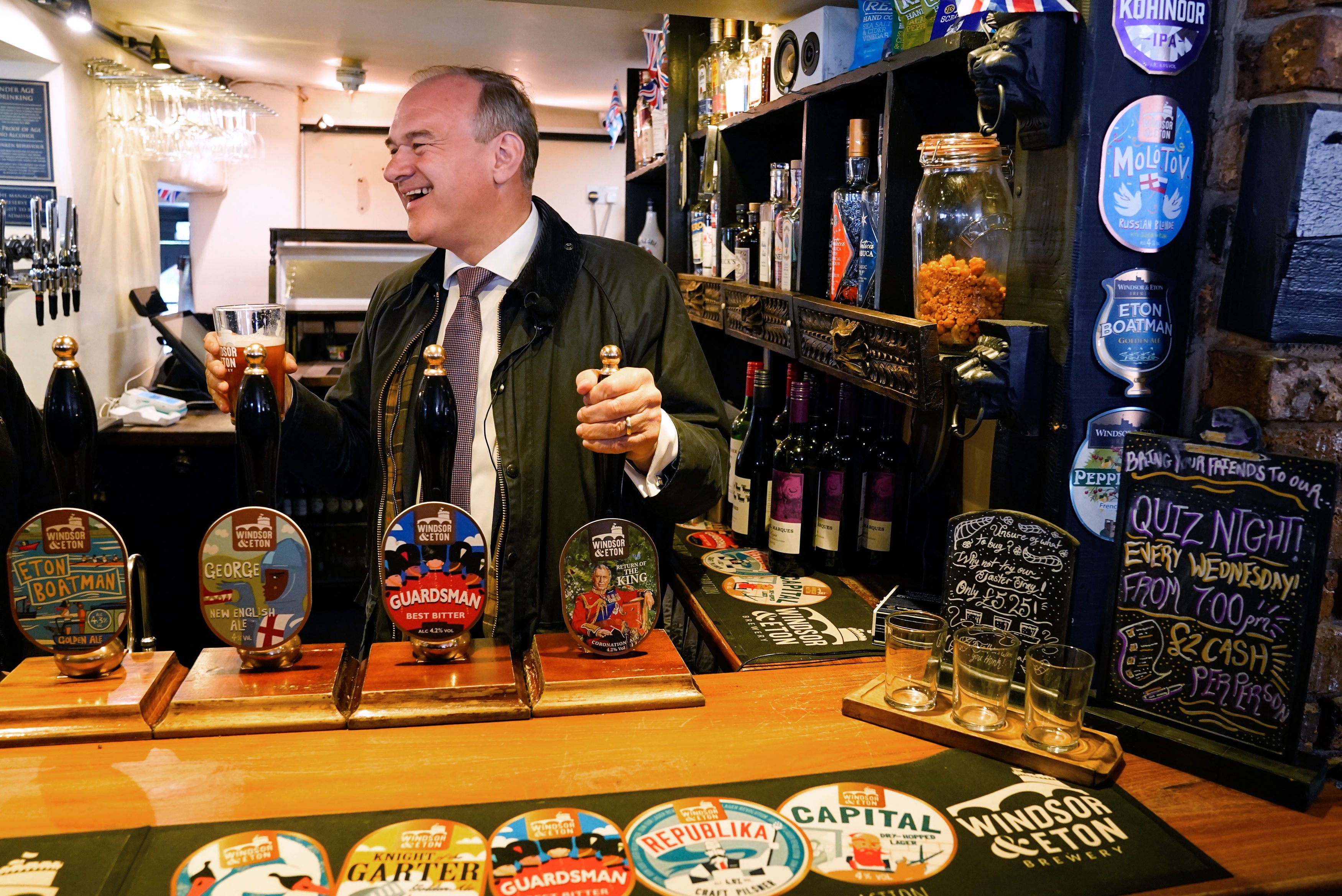 Leader of the Liberal Democrats Sir Ed Davey pulls a pint of 'Return of the King' in the George Inn pub during a visit to Windsor, Berkshire