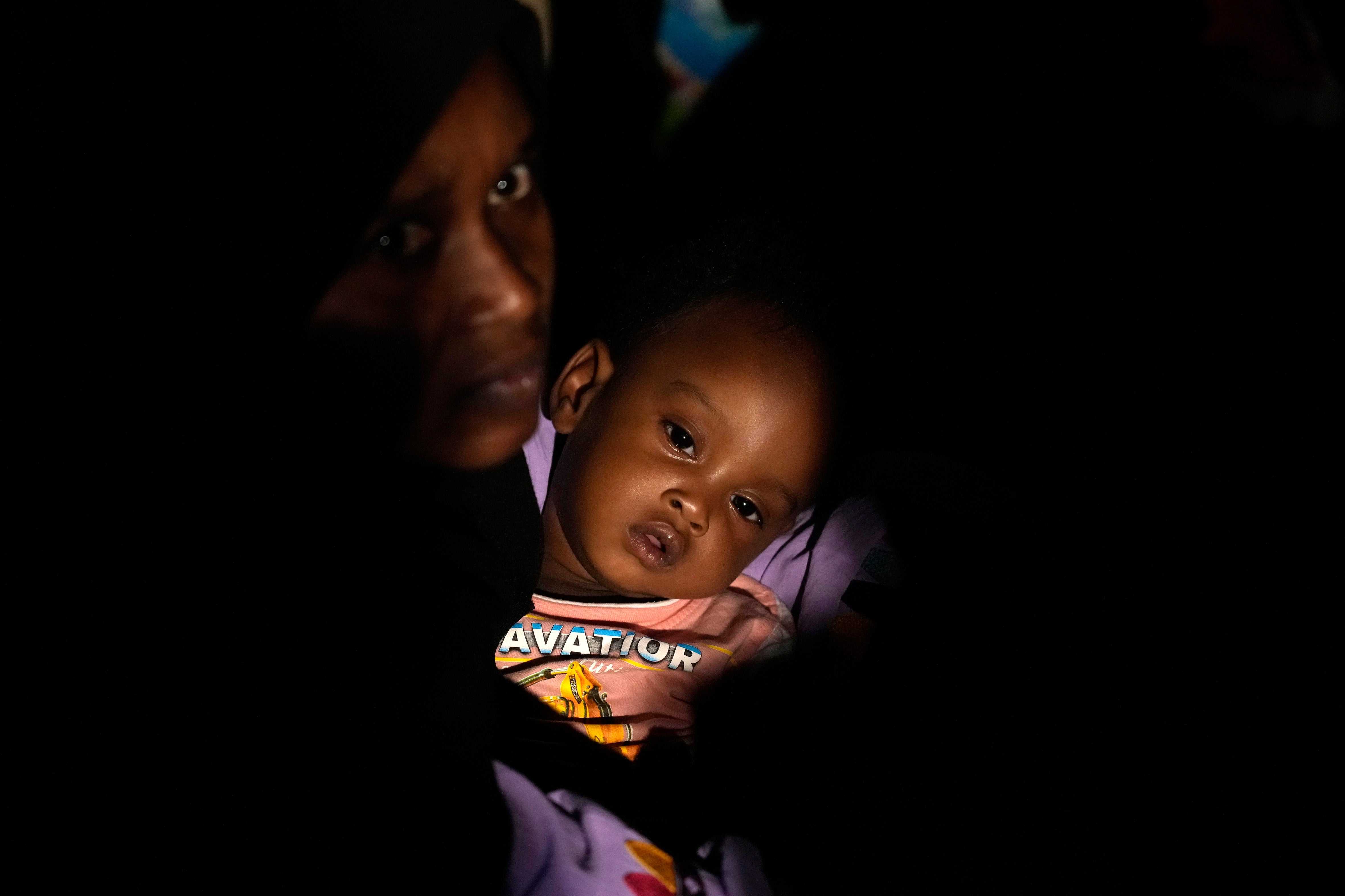 Sudanese evacuees wait before boarding a Saudi military ship to Jeddah port, at Port Sudan, on 2 May