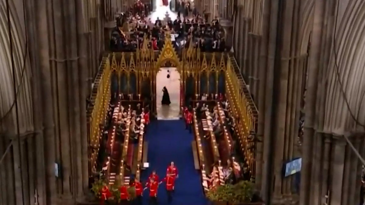 Moment mysterious cloaked figure runs past Westminster Abbey during coronation