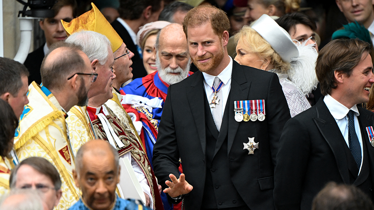 Prince Harry smiles as he leaves King Charles’s coronation