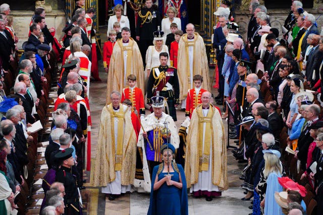 The King, wearing the Imperial State Crown, is followed by Queen Camilla as they leave Westminster Abbey (Ben Birchall/PA)