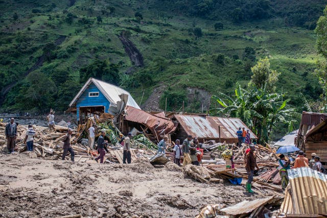 <p>People walk next to houses destroyed by the floods in the village of Nyamukubi, South Kivu province, in the Democratic Republic of Congo on Saturday</p>