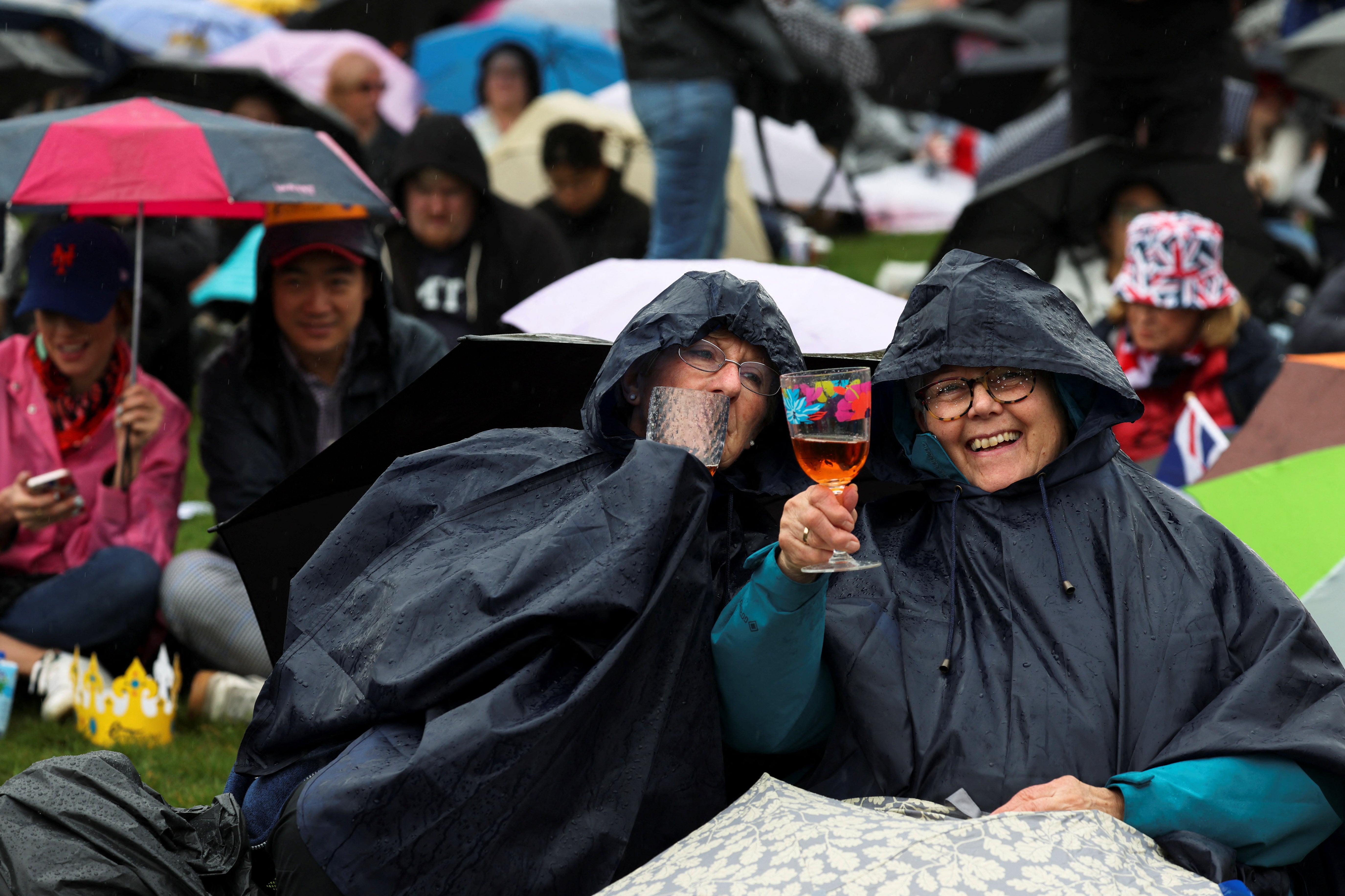 Mary Davis and Carol Sills from Bedfordshire sit in the rain at Hyde Park