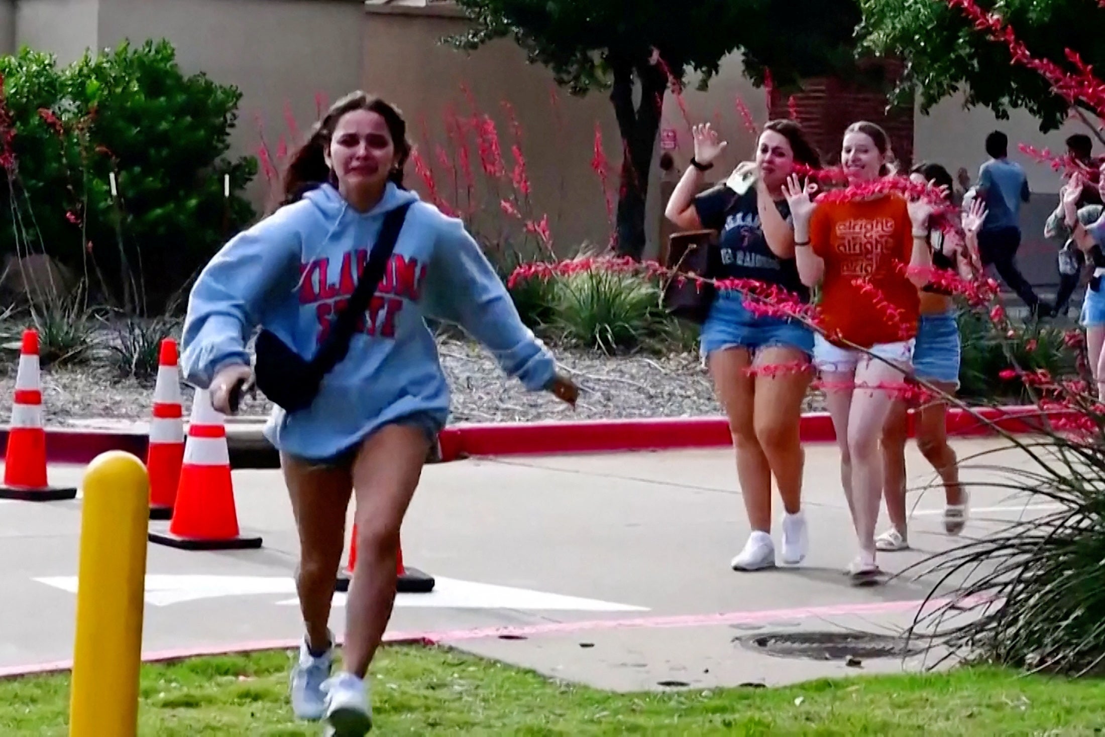 A girl runs as other shoppers leave with their hands up after a mass shooting at a mall in Allen, Texas