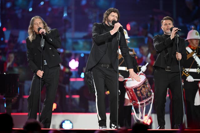 Mark Owen, Howard Donald and Gary Barlow from Take That on stage at the Coronation Concert (PA)