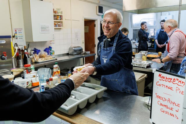 The Archbishop of Canterbury Justin Welby serves lunch during his visit to the Catching Lives Open Centre (Neil Turner/PA)