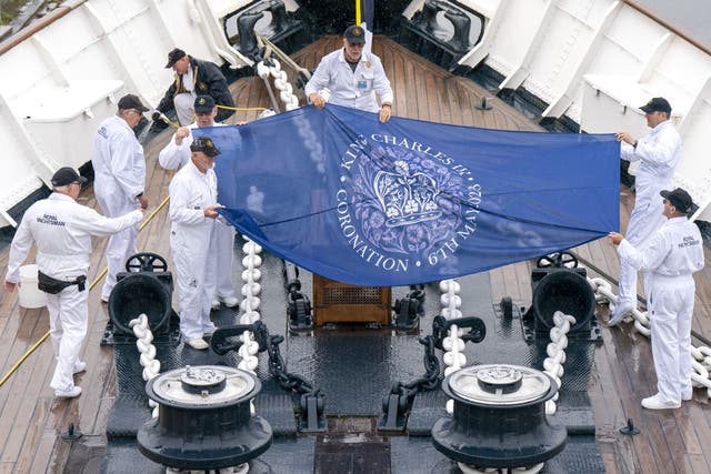 Royal yachtsmen, known as ‘Yotties’, with the coronation flag on their return to the Royal Yacht Britannia, in Leith, Edinburgh , to resume their duties (Jane Barlow/PA)