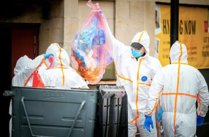 Forensic officers were seen looking into bins at the scene