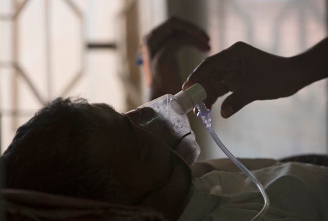 <p>A relative adjusts the oxygen mask of a tuberculosis patient at a TB hospital on World Tuberculosis Day in Hyderabad, India </p>