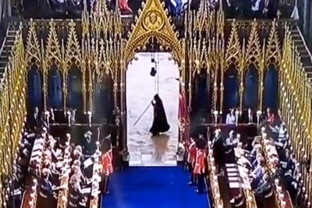 <p>A cloaked figure seen scuttling across the floor of Westminster Abbey at the King’s coronation</p>