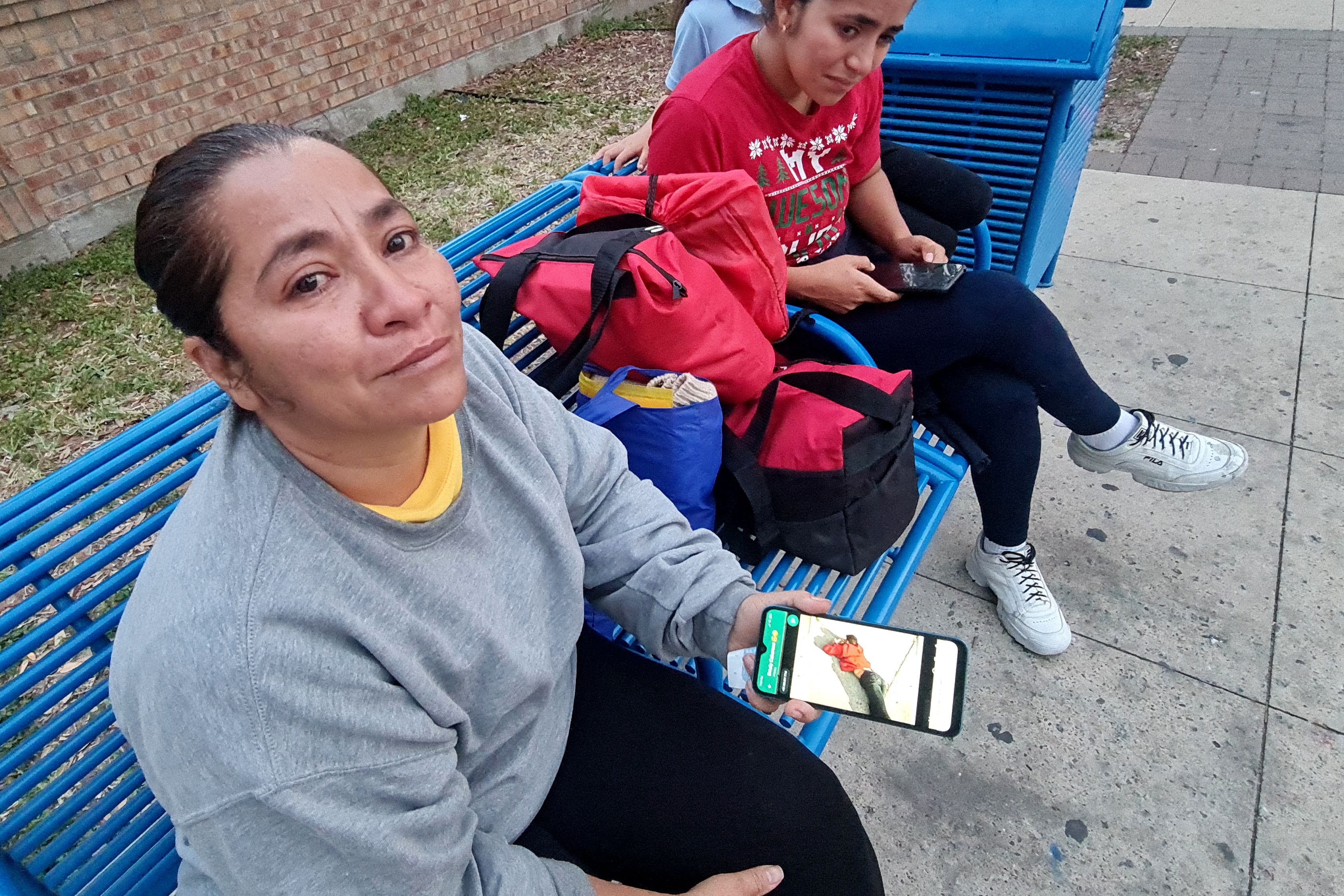 Venezuelan Maria Cabarcas (L), 43, holds her phone with the picture of who she believes is her deceased son, Enyerbeth Cabarcas, 23, who allegedly was one of the eight victims after an SUV plowed into a crowd, in Brownsville, Texas on 8 May 2023