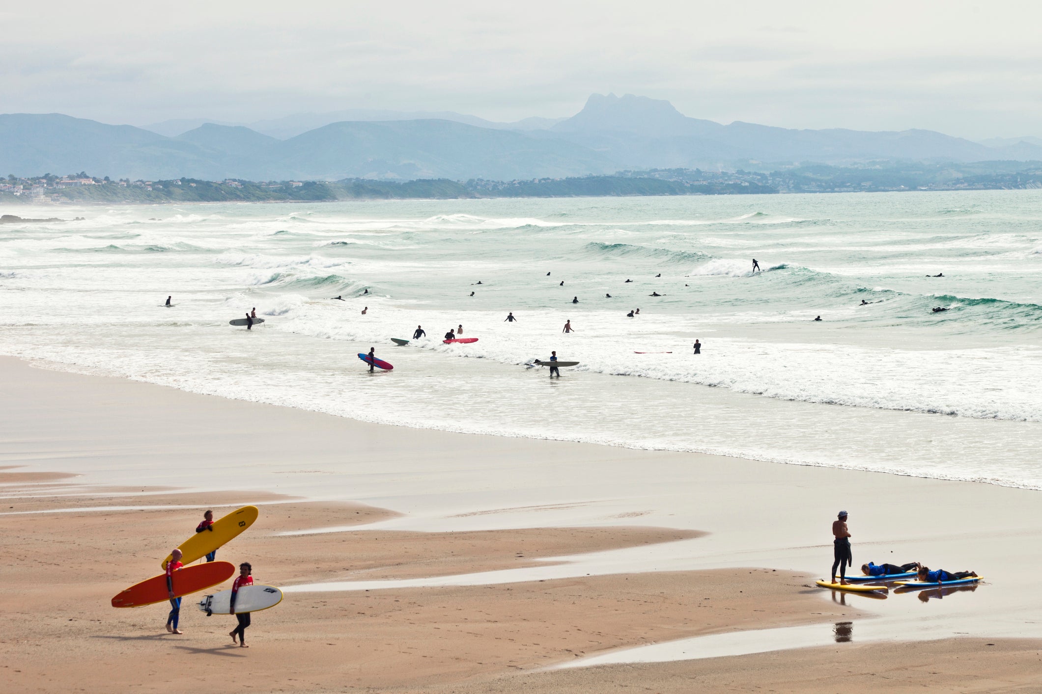 Surfers catch the waves at La Cote des Basques beach in Biarritz