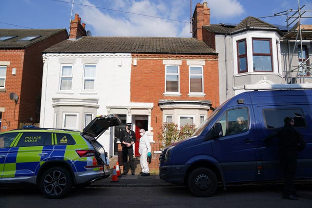 Forensic officers at the scene in Northampton following a discovery of a body in a rear garden (PA)