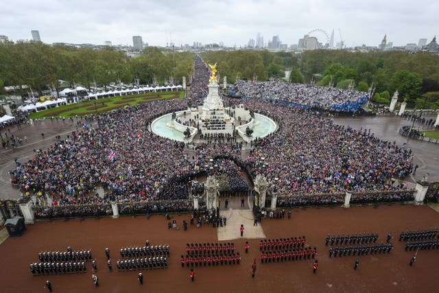 Members of the public wait for the flypast by aircraft from the Red Arrows over the Mall following the coronation of the King (Bruce Adams/The Daily Mail/PA)