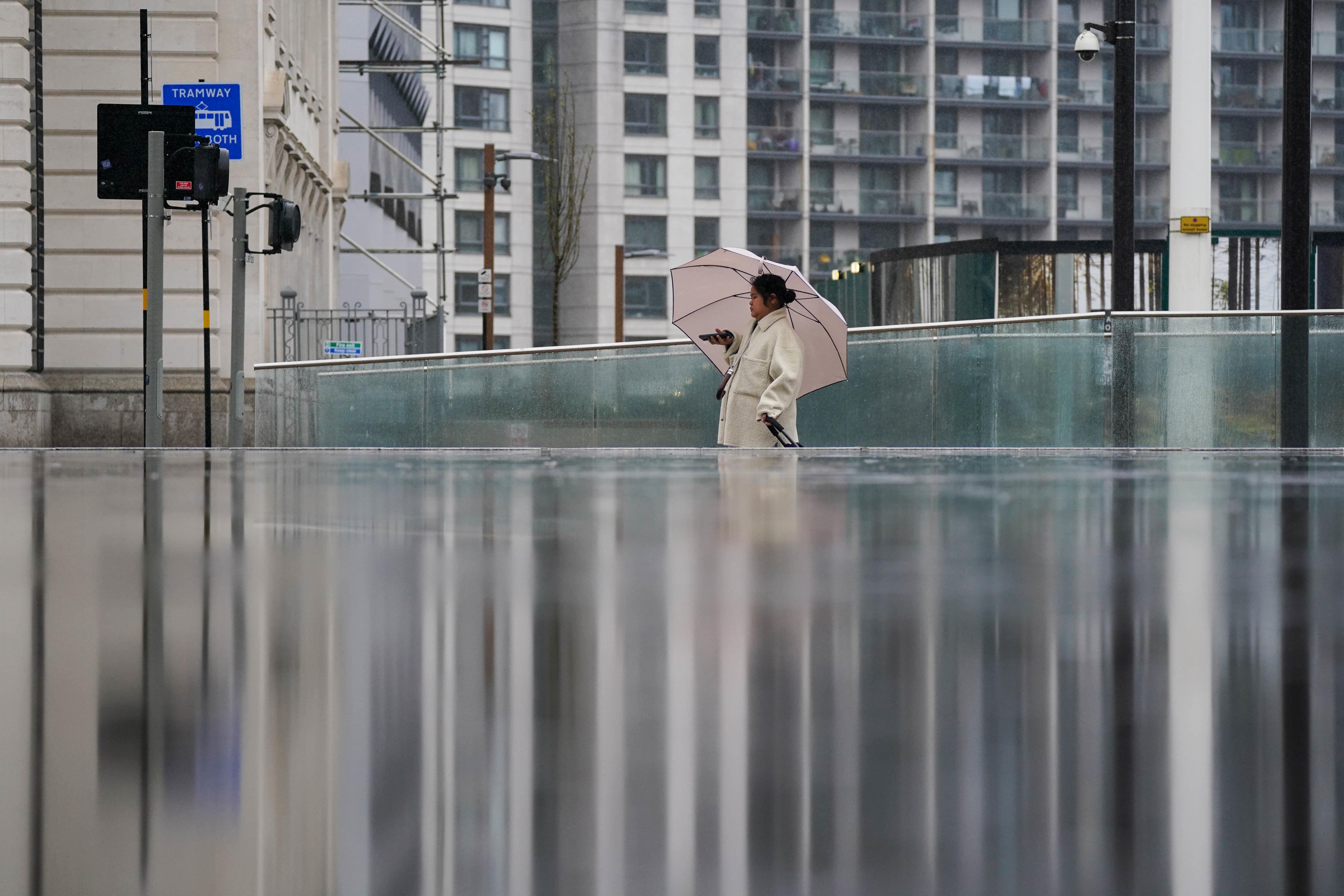 People walk through Centenary Square in Birmingham during rain showers in March (Jacob King/PA)