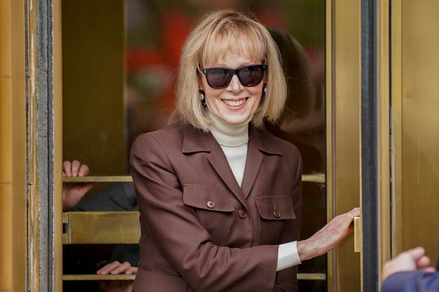 <p>E Jean Carroll smiles as she leaves court after a jury awarded her nearly $5m </p>