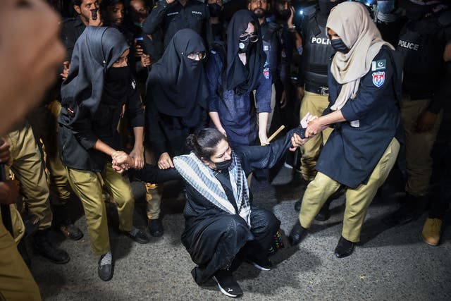 <p>An Imran Khan supporter is held by police in Karachi on Wednesday </p>