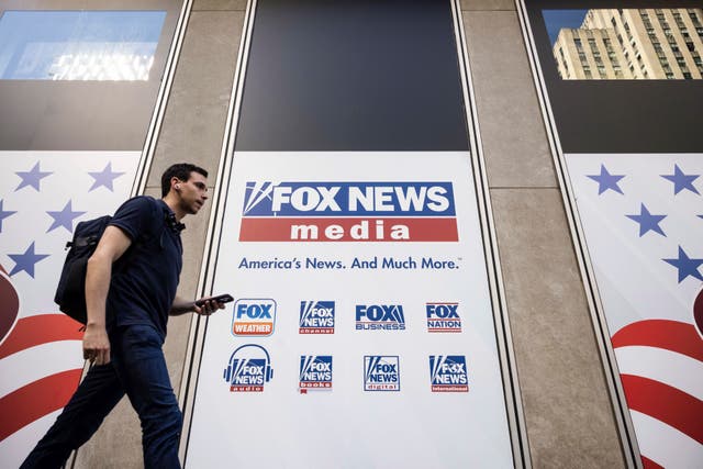 <p>FILE - A person walks past the Fox News Headquarters in New York on April 12, 2023.</p>