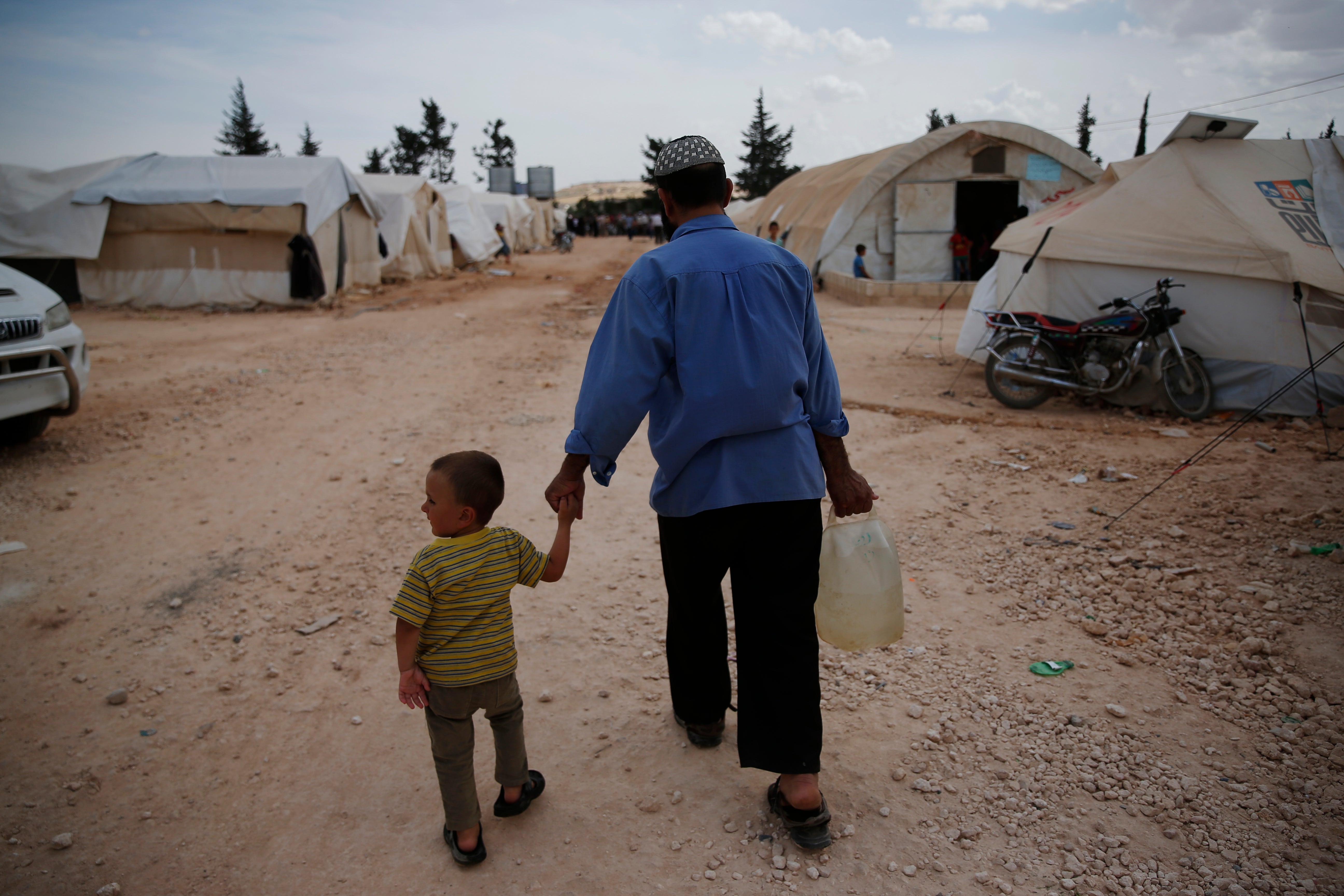 Syrians walk in a camp for internally displaced people in al-Bab, northern Syria