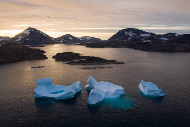 <p>Large Icebergs float away as the sun rises near Kulusuk, Greenland</p>