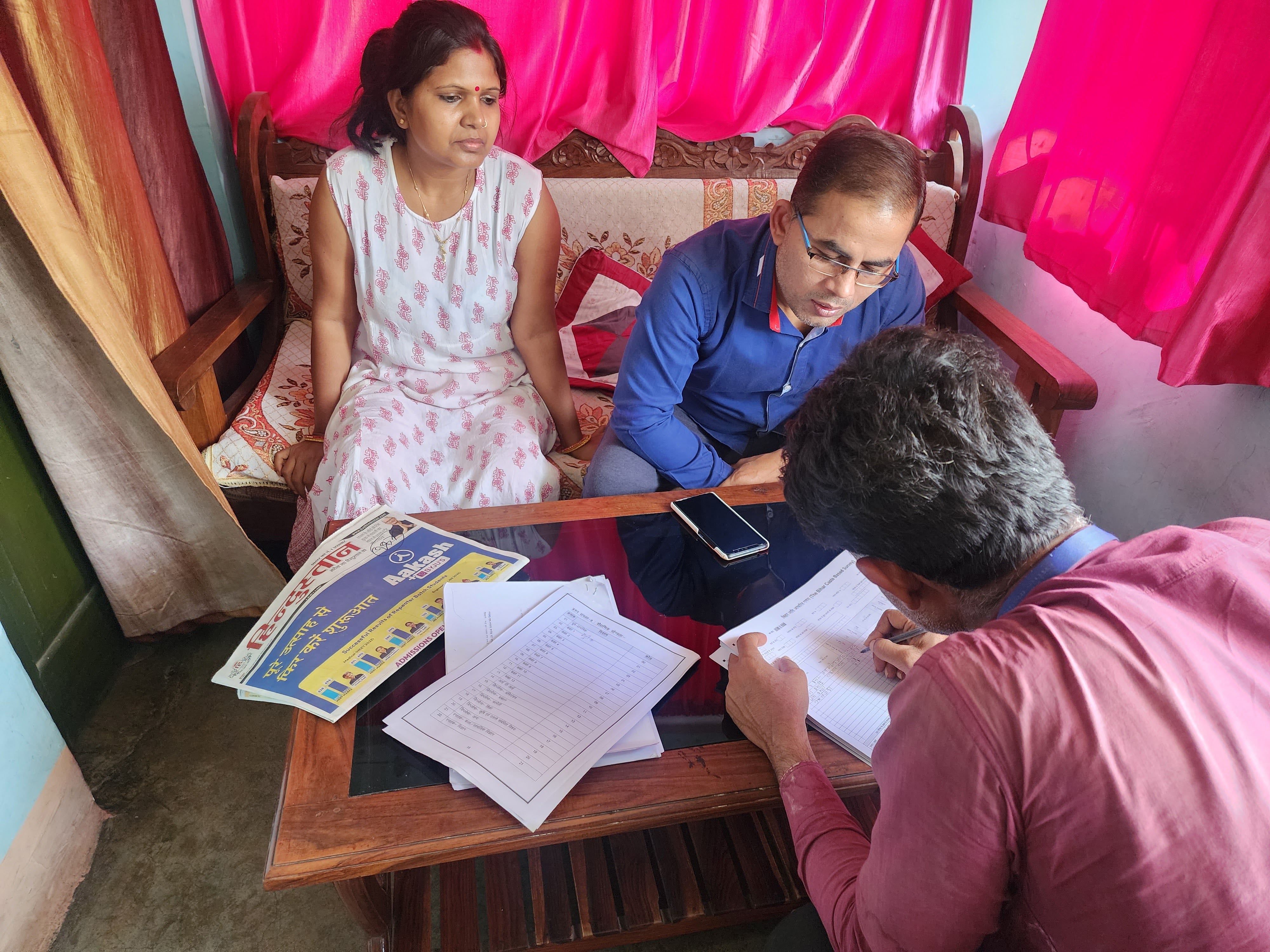 Rita Kumari and Virendra Kumar watch Paswan record their socioeconomic and caste information