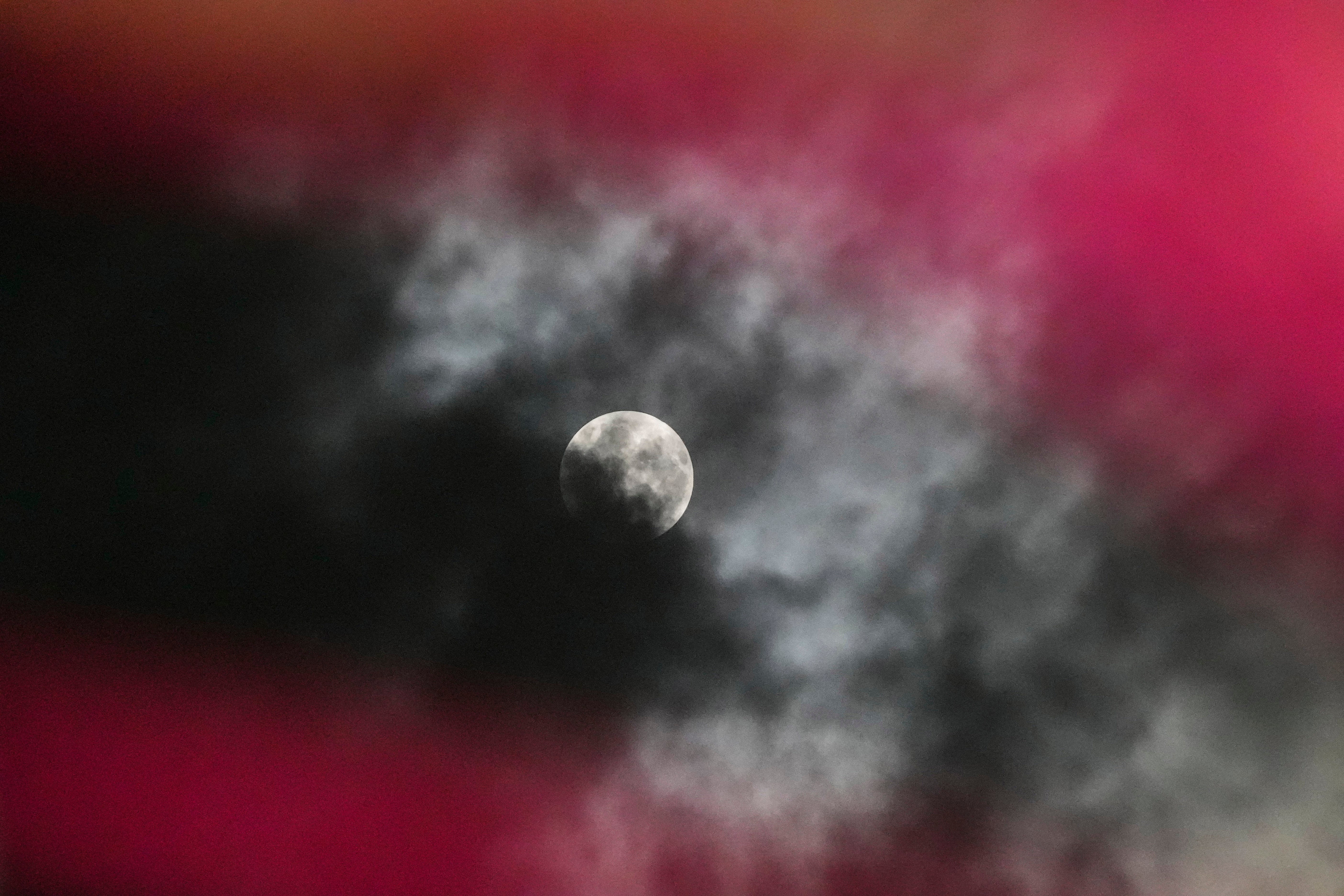 A penumbral lunar eclipse is seen through clouds during the early hours of Saturday in Srinagar, Indian controlled Kashmir, 6 May, 2023