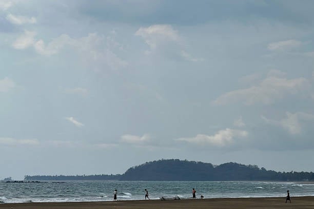 People walk on Kan Thar Yar beach near Gwa township, on 11 May 2023 after cyclone Mocha, the Bay of Bengal’s first cyclone of the year, formed